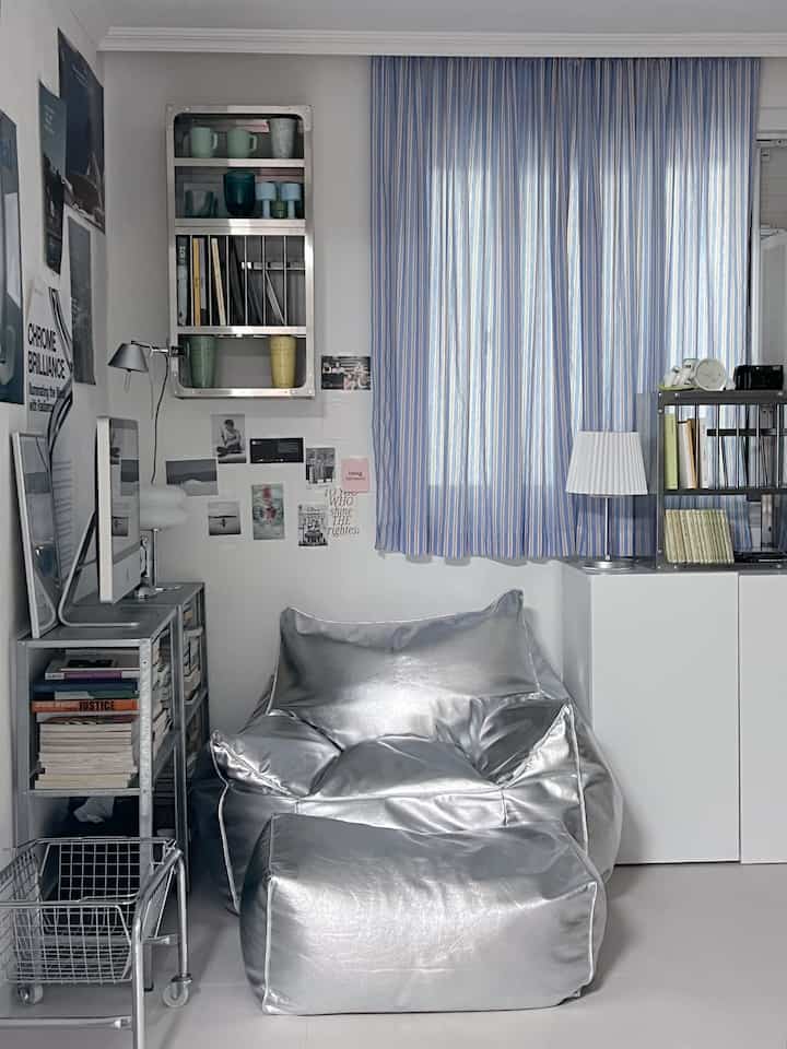 シルバー色調の狭い部屋、シルバービーンバッグとスチール家具が配置されたモダンな雰囲気のインテリア