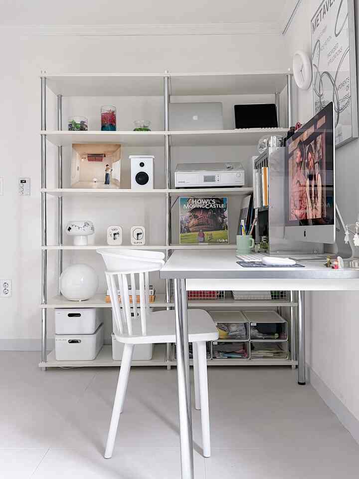 明るいホワイトトーンのシンプルなホームオフィス、机と本棚、整頓された収納が配置された雰囲気のあるインテリア