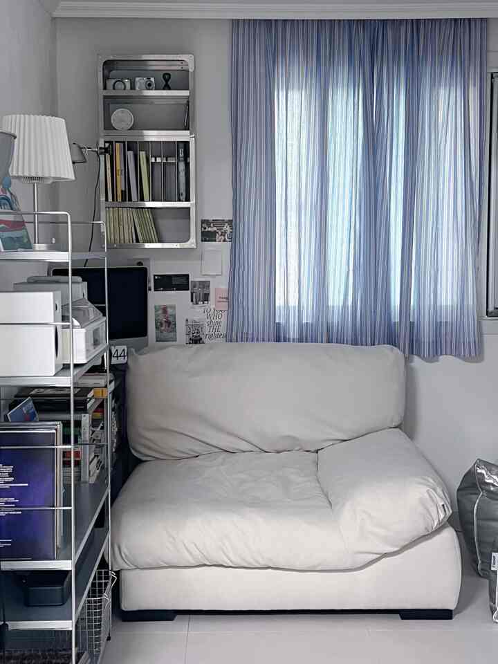 ホワイトとブルーのトーンの小さな空間、中央にクリーム色のビーズクッションが配置された清潔感のあるリラックススペース