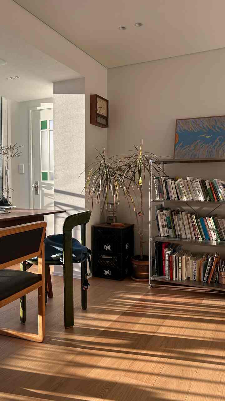 暖かいウッドトーンの床とダイニングテーブル、ダイニングチェアが配置されたナチュラルなリビングルーム