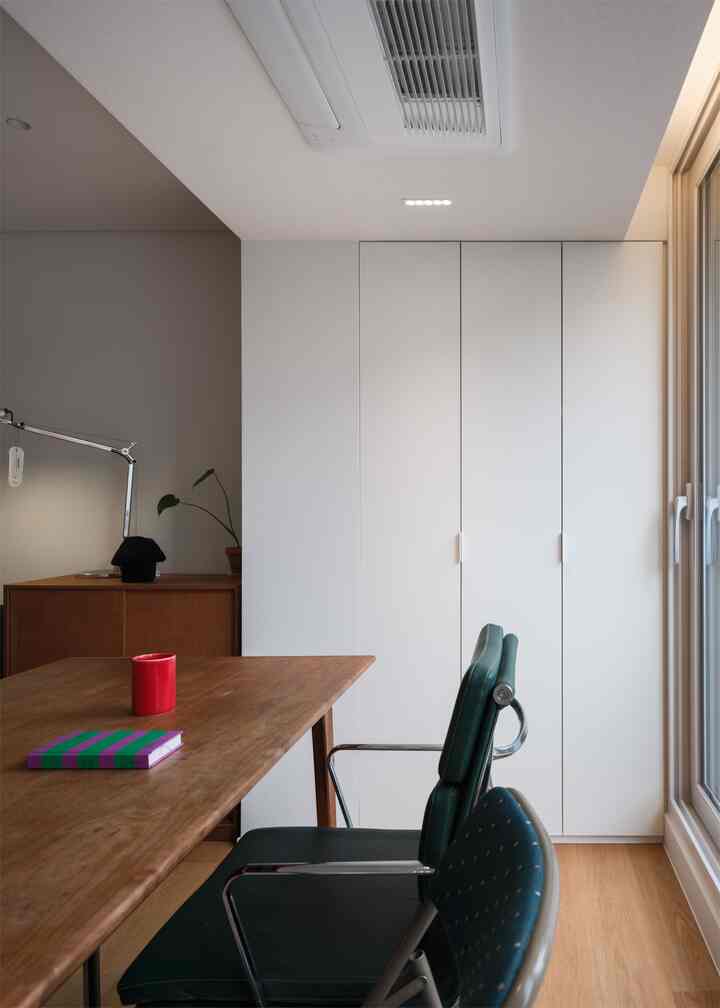 白い壁と木目調のデスクが配置されたシンプルなホームオフィス
