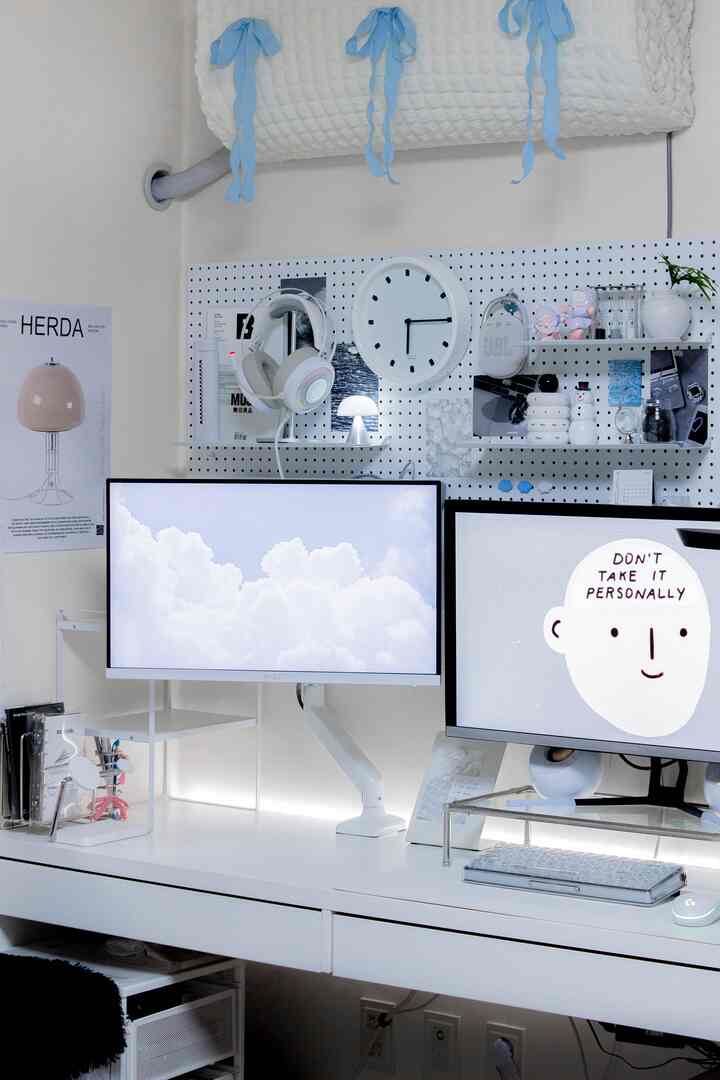 白を基調としたホームオフィス空間、狭い部屋に合わせたコンパクトなデスクとペグボード収納が配置されたシンプルで整理された作業環境