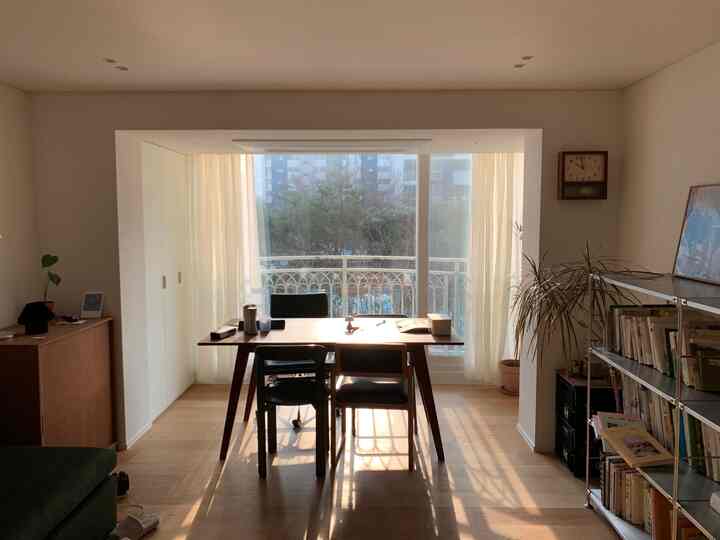 ナチュラルウッドトーンとベージュカーテンが調和した拡張型ダイニングリビング空間