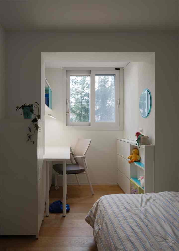 ホワイトとウッドトーンの調和が取れたコンパクトなシングルベッドルーム兼ホームオフィス、シンプルで整頓された収納が特徴的な空間