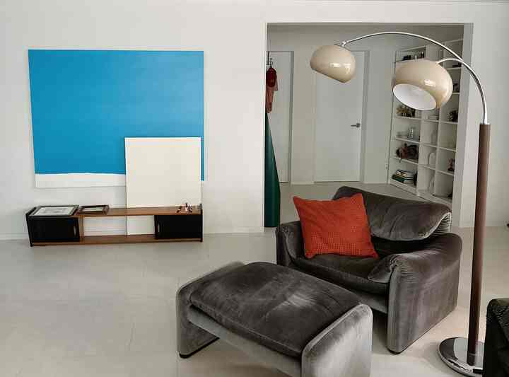 白とグレーのトーンのモダンなリビングルーム、グレーのソファとオブジェが配置されたシンプルで洗練されたインテリア