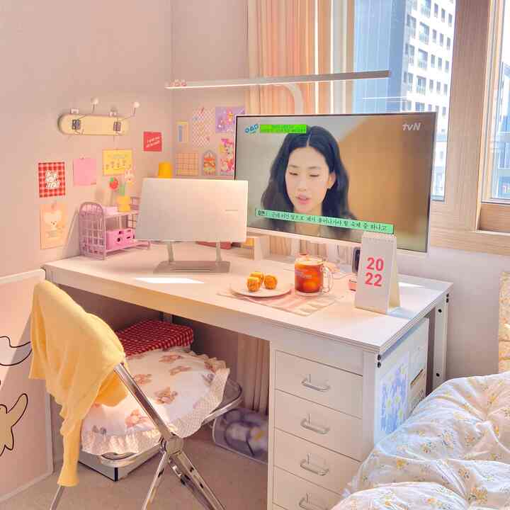 白と黄色のトーンが特徴の書斎、机にノートパソコンとモニター、折りたたみ椅子が配置された落ち着いたインテリア