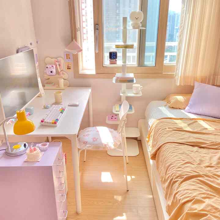 温かみのあるナチュラルカラーの狭い寝室、ホワイトのデスクとラベンダー色のチェスト、ホワイトの棚、ベージュの寝具が調和した印象的なインテリア