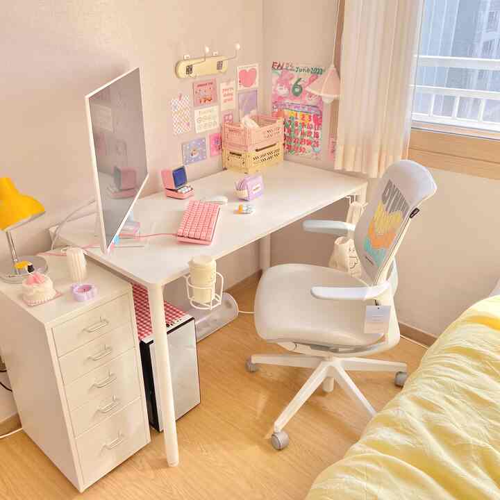 白と黄色のトーンの寝室兼ホームオフィス。デスクとオフィスチェア、ホワイトモニターが配置された印象的で清潔感ある空間