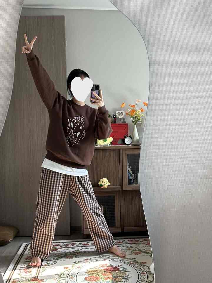 ブラウンとホワイトの色調が特徴の玄関、波形の大きな鏡と木製キャビネットが配置されたナチュラルな印象のインテリア