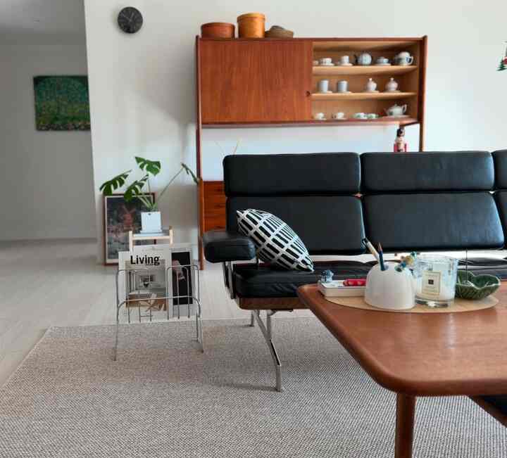 ナチュラルな木目調と黒のレザーソファが配された北欧スタイルのリビングルーム空間