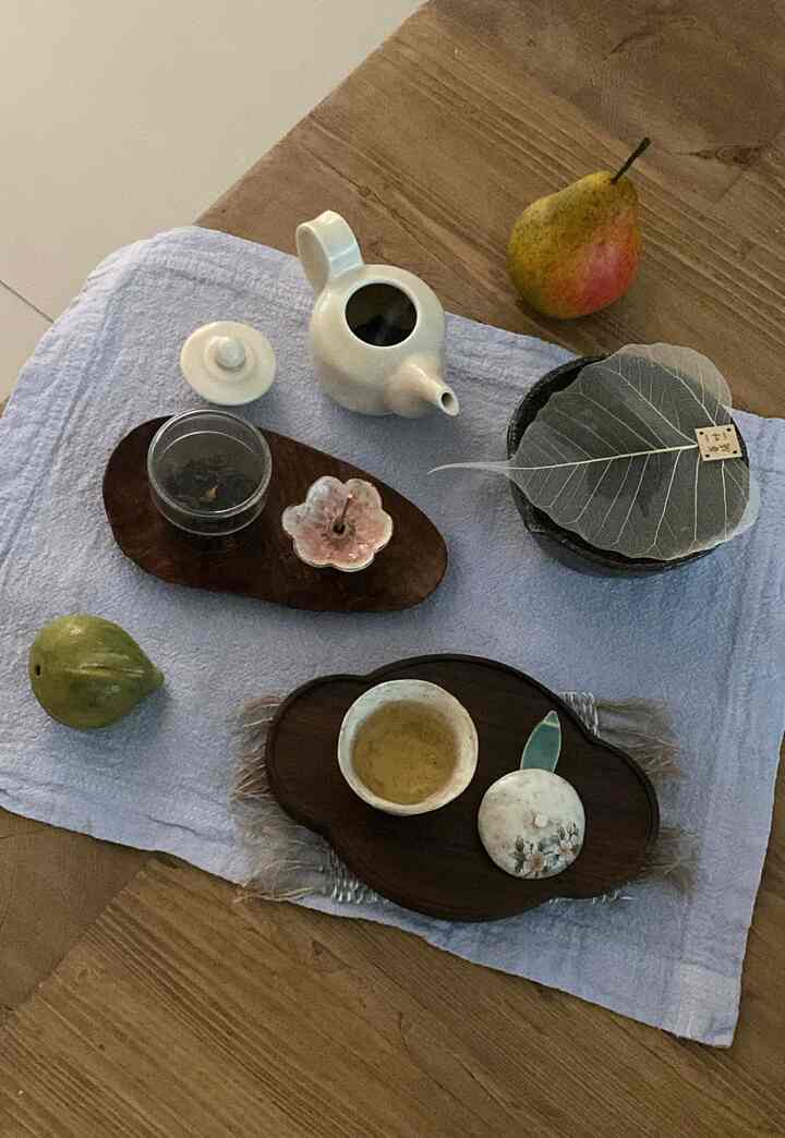 温かみのあるナチュラルな木目調のテーブルに配置されたおうちカフェの茶器とティーカップのある雰囲気のある空間