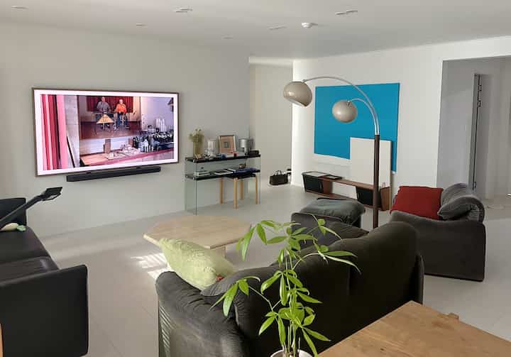 白とグレーのトーンのモダンなリビング、2つのソファとコーヒーテーブル、フロアランプが配置された清潔感のある空間