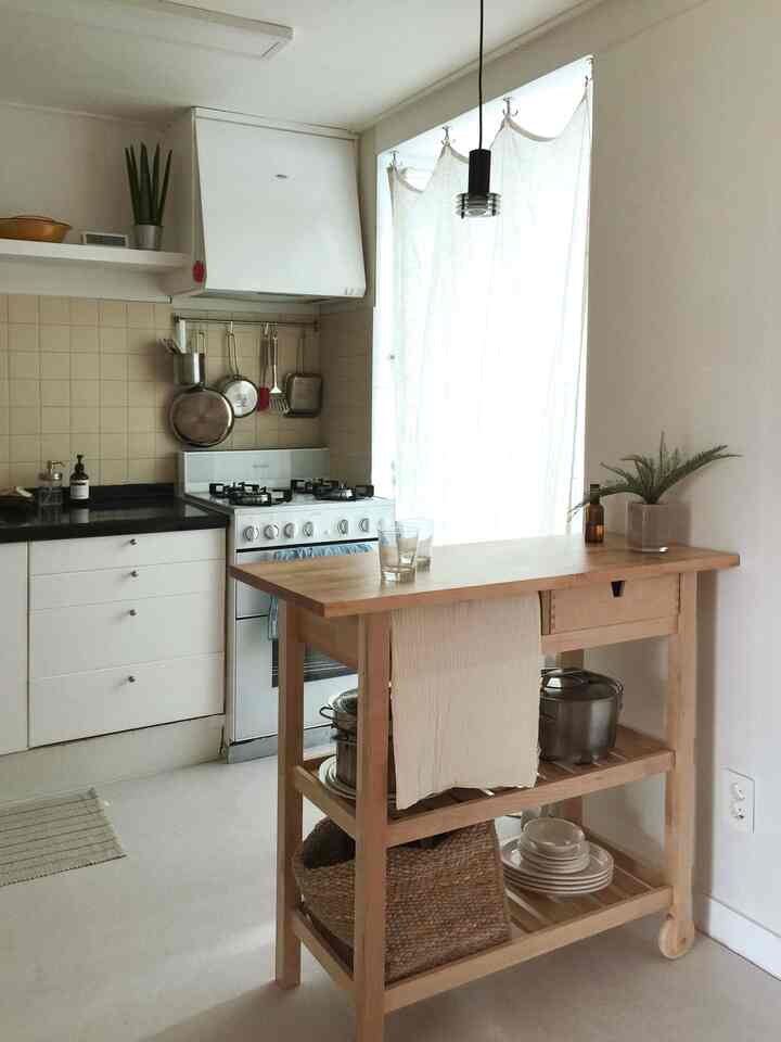 ナチュラルな木目調と白を基調としたキッチン、イケアの棚とキッチン用品が整然と配置された雰囲気のある空間