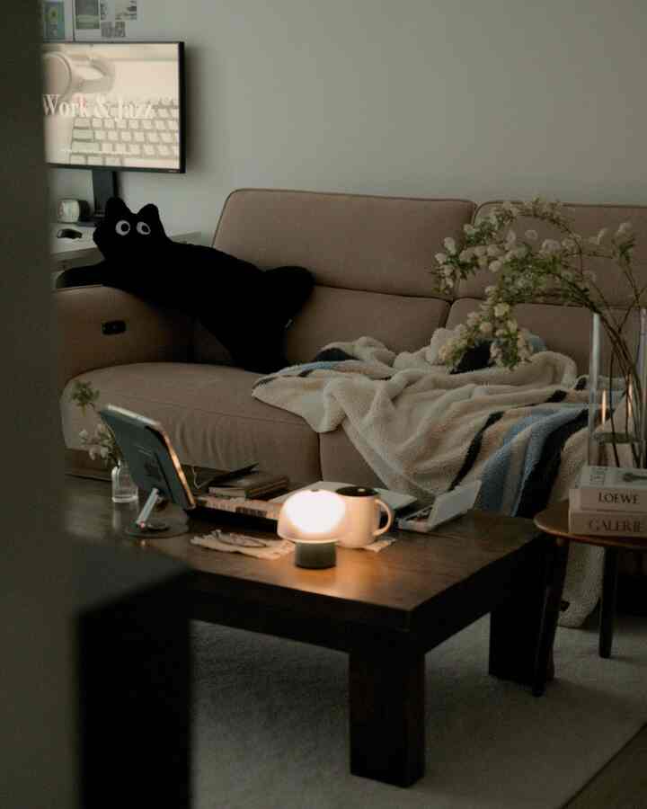 ナチュラルな色調のワークスペース、ベージュのソファとダークウッドのコーヒーテーブルが配置された雰囲気のあるヴィンテージ風リビング。