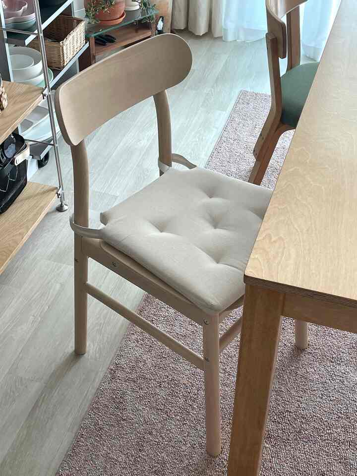 ナチュラルな色調のダイニングスペース、自然光の中で木製のダイニングテーブルとチェアが配置された雰囲気のあるインテリア