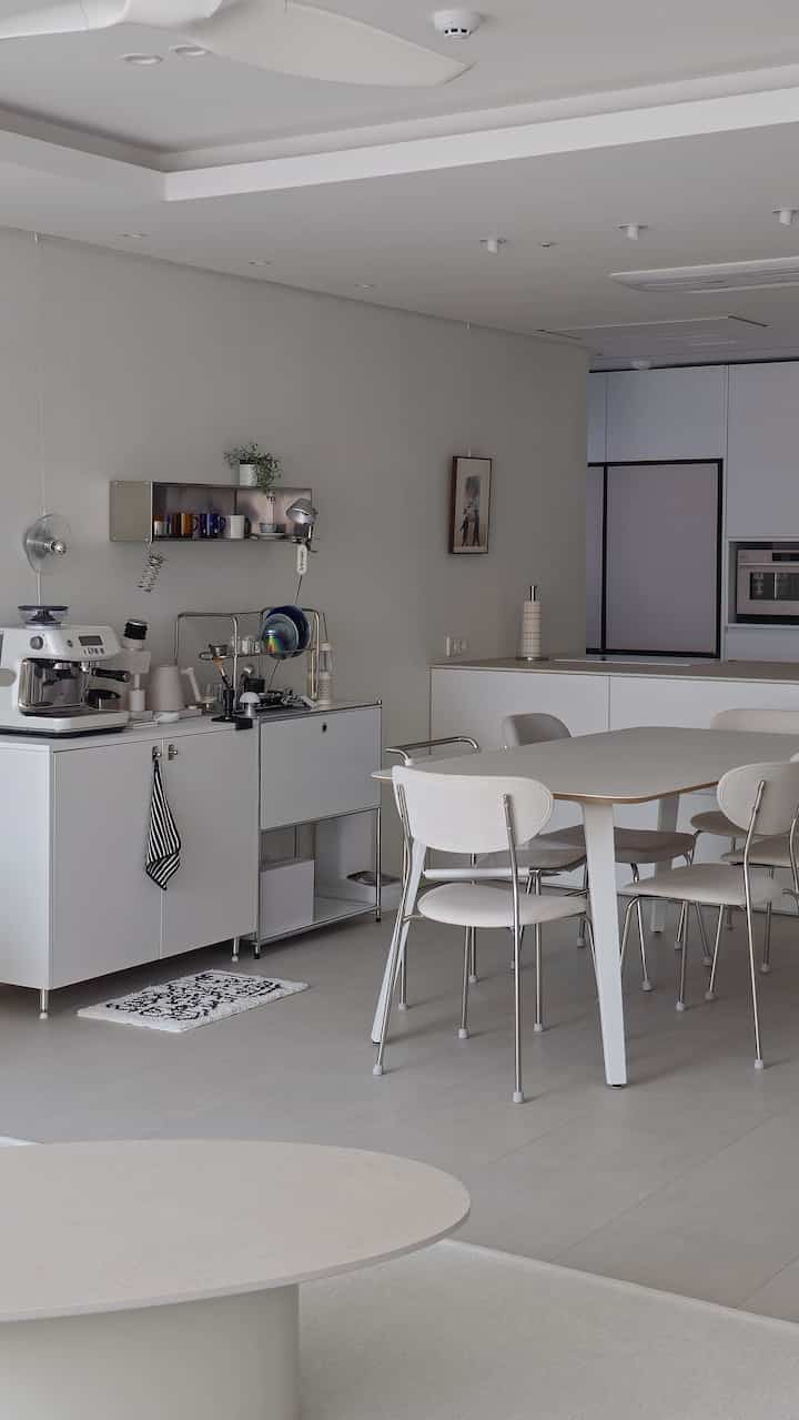 白とグレーのトーンのキッチンとダイニング、シンプルモダンなホームカフェの雰囲気あるインテリア