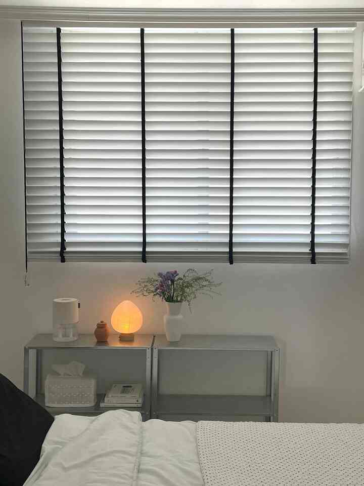 白と黒のモノトーンが主体の寝室、IKEAのメタル棚とムードランプが配置され、落ち着いた雰囲気のインテリア