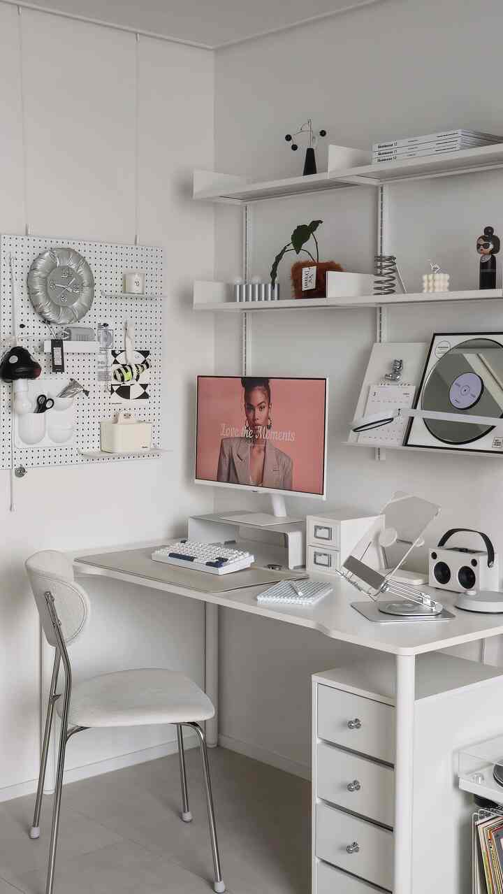 白とシルバーの色調のホームオフィス、デスクとモニタースタンドが配置されたミニマルで落ち着いた雰囲気のインテリア