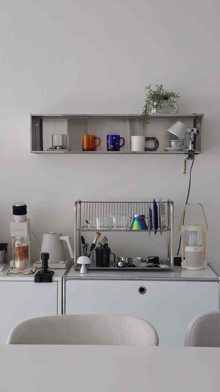 シルバーのトーンのキッチン、カップと食器乾燥ラックが整然と配置されたモダンなおうちカフェのインテリア