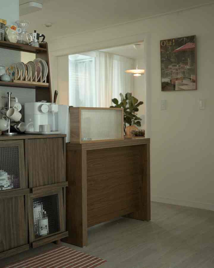 白と木目調が調和したモダンなキッチン空間、コーヒーマシンと整頓された収納家具が配置されたおうちカフェの雰囲気