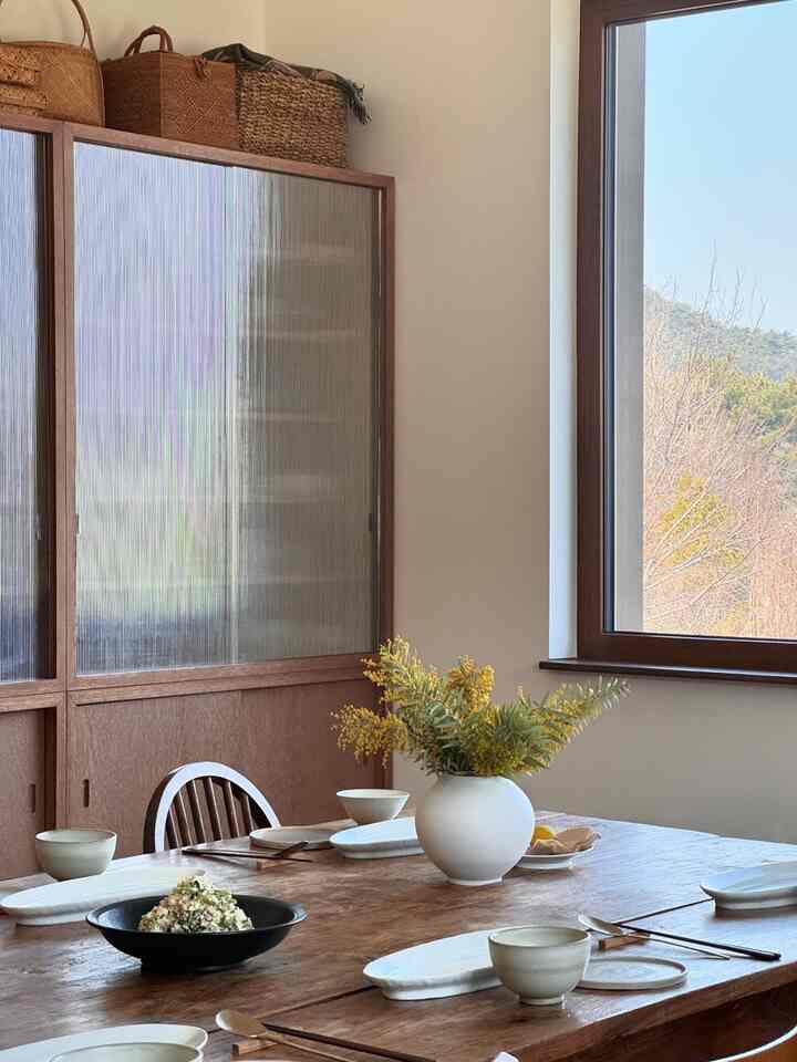 白と木目調のダイニング、広い窓と自然光が印象的な雰囲気あるインテリア