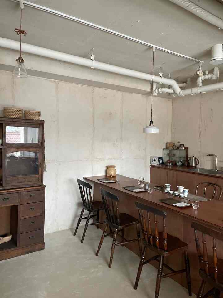 ナチュラルな色調のティールーム、高級家具と木製のダイニングチェアが配置された落ち着いた空間