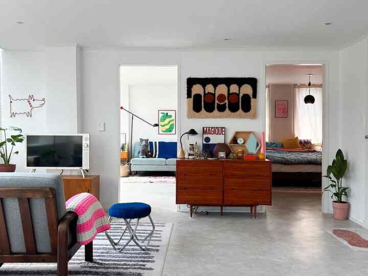 白い壁と木目調の家具が調和した4人暮らし向けのモダンでナチュラルなリビングと寝室のインテリア