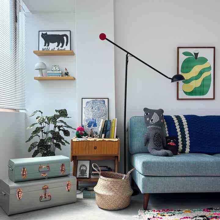 ナチュラルな色調とブルーが調和するリビング、ソファや木製の収納台、小物が配置された雰囲気のあるインテリア