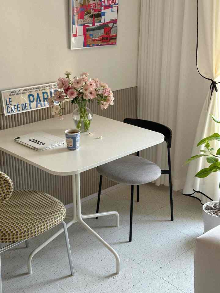 ナチュラルな色調のリビングダイニング、コンパクトな四角テーブルと異なるデザインの椅子が配置された雰囲気のあるインテリア