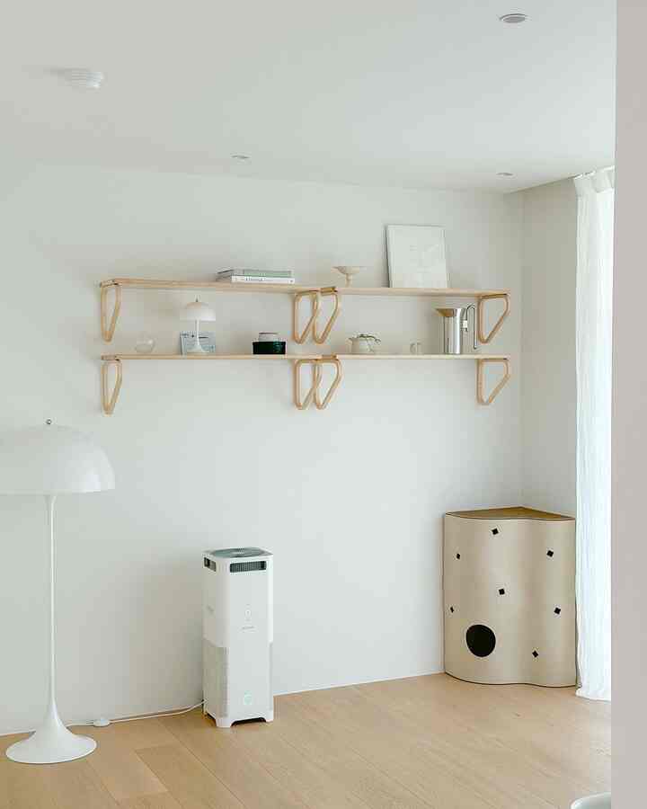 白と木目調の書斎、棚とフロアランプ、コーナーに配置された猫用ペットハウスがあるシンプルで落ち着いたインテリア