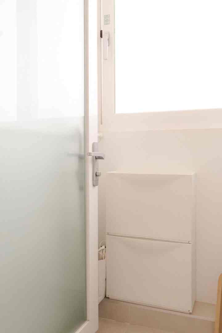 明るいホワイトトーンの多目的室に設置されたシューズラックが見える、清潔感のあるキッチンインテリア