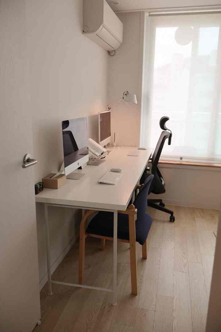 白とナチュラルカラーが調和したホームオフィス、洗練されたデスクとオフィスチェアが配置された雰囲気のあるインテリア