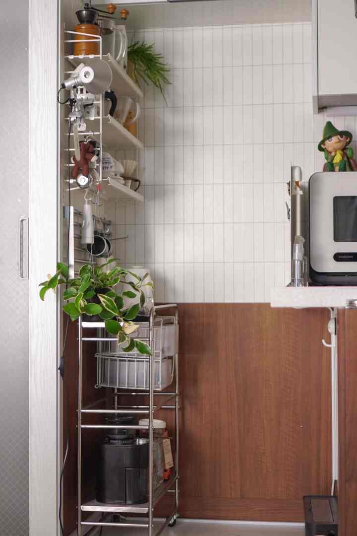 ホワイトタイルの壁とブラウンの壁面にステンレスのトロリーと棚が配置されたコンパクトなおうちカフェ空間