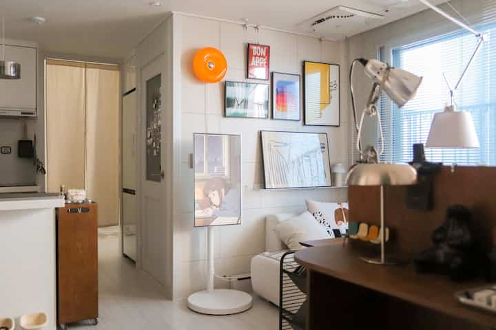 白を基調としたリビング、ナチュラルモダン家具と額縁が配置された雰囲気のあるインテリア