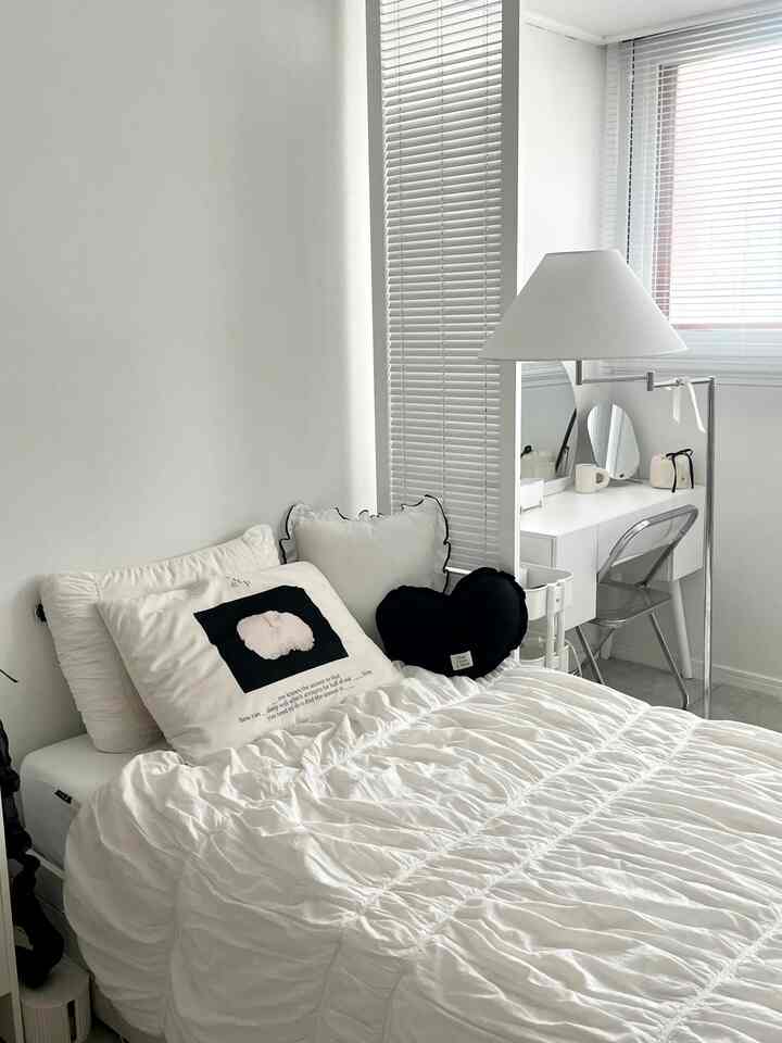 ホワイトとブラックの配色のシンプルモダンな寝室、シャーリングの寝具と化粧台が配置された清潔感のあるインテリア