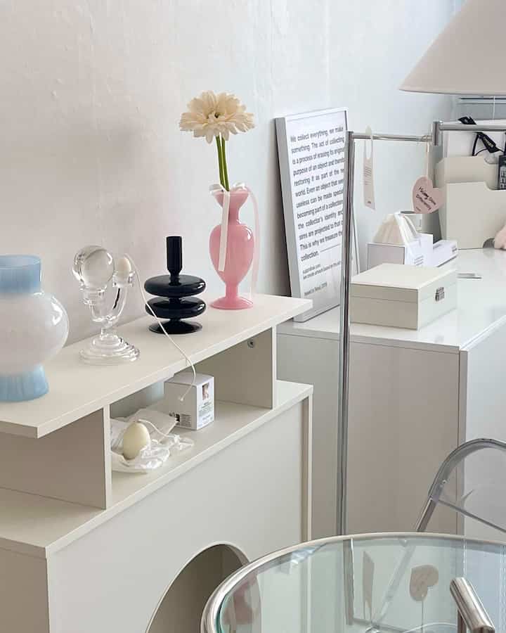 白と透明素材が調和したモダンなリビング、コンソールテーブルとフロアランプが配置された清潔感のある空間