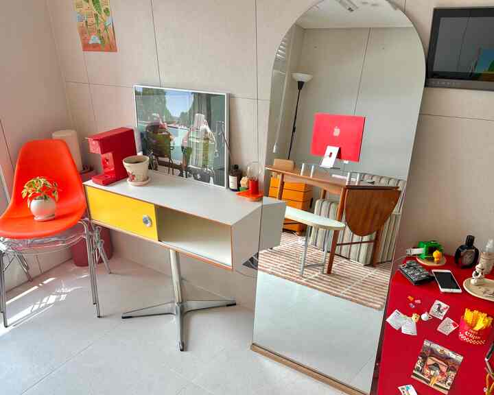 暖かい赤と黄色のトーンの狭い部屋、ミッドセンチュリーモダン家具と大きなアーチ型の鏡が配置された居心地の良いおうちカフェ空間