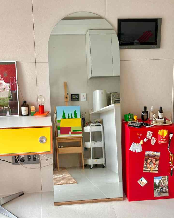 黄色のチェストと赤い冷蔵庫が並ぶミラーのあるキッチンの雰囲気のあるインテリア