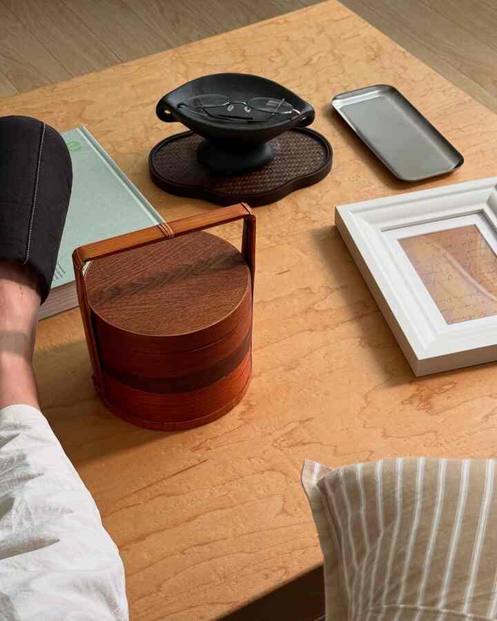 木目調の座卓にウッド弁当箱や眼鏡、トレイが置かれたシンプルで自然な雰囲気のインテリア