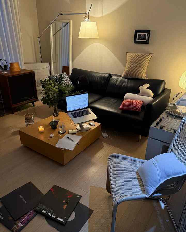 ブラウンの床のリビング、黒のレザーソファと木製のコーヒーテーブルが配置されたモダンな作業空間