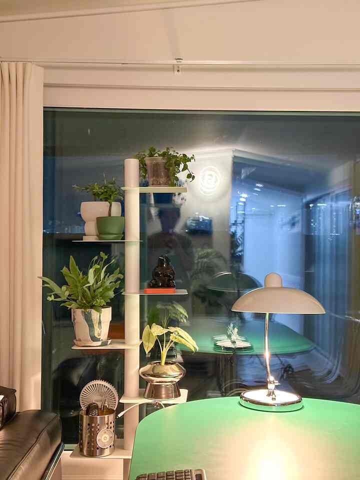 ナチュラルな雰囲気のダイニング、中央にカイザーイデルのテーブルランプと緑のダイニングテーブルが配置された印象的な空間