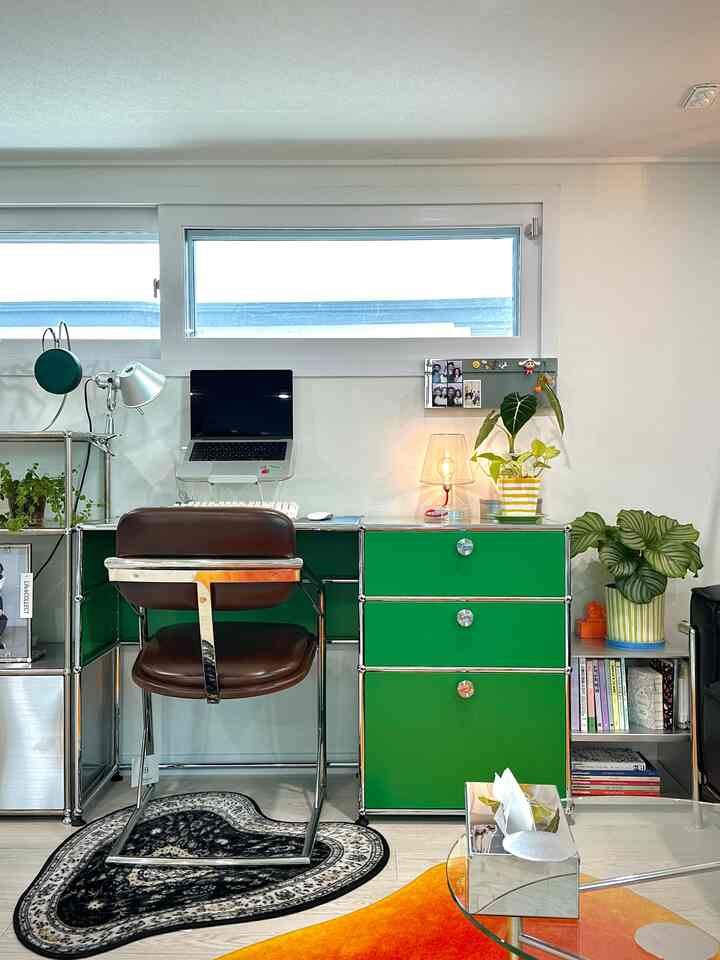 緑と茶色のトーンが特徴のホームオフィス、モジュール式デスクと快適なオフィスチェア、植物と収納が調和した雰囲気のあるインテリア