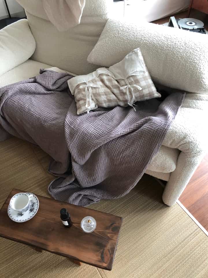 ホワイトとベージュの色調が調和したリビング、ヴィンテージソファと木製コーヒーテーブルが配置された雰囲気のあるインテリア