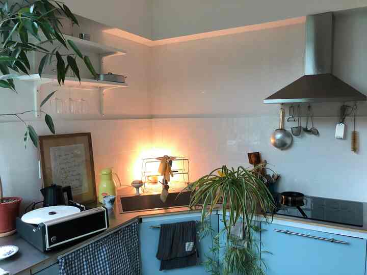 ナチュラルな雰囲気のキッチン、スカイブルーのキャビネットとシルバーのカウンターが配置されている空間