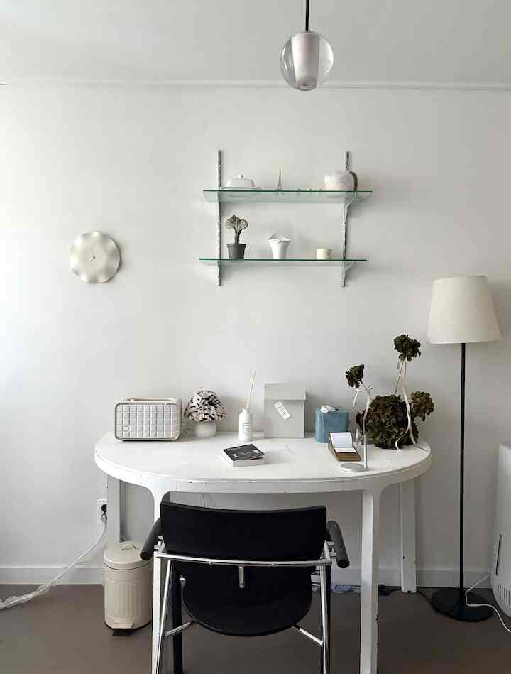 ホワイトトーンのシンプルモダンなホームオフィス、中央に白いデスクと黒いオフィスチェアが配置された清潔感のある空間