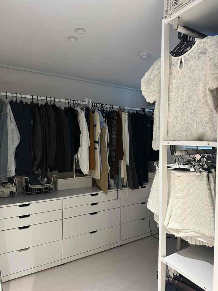 白を基調としたウォークインクローゼット、ノルドリチェストと壁ハンガーが整然と配置された収納空間。