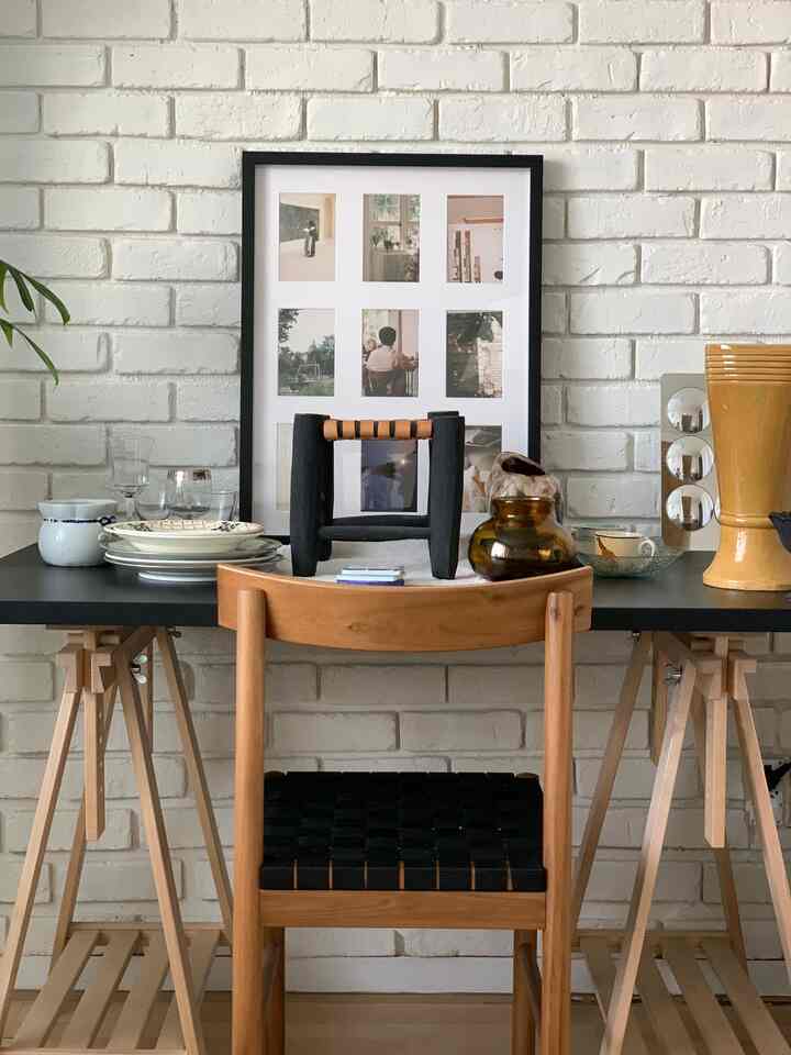 ホワイトブリックの壁と木目調のデスク、椅子が調和するシンプルな一人用ワークスペース