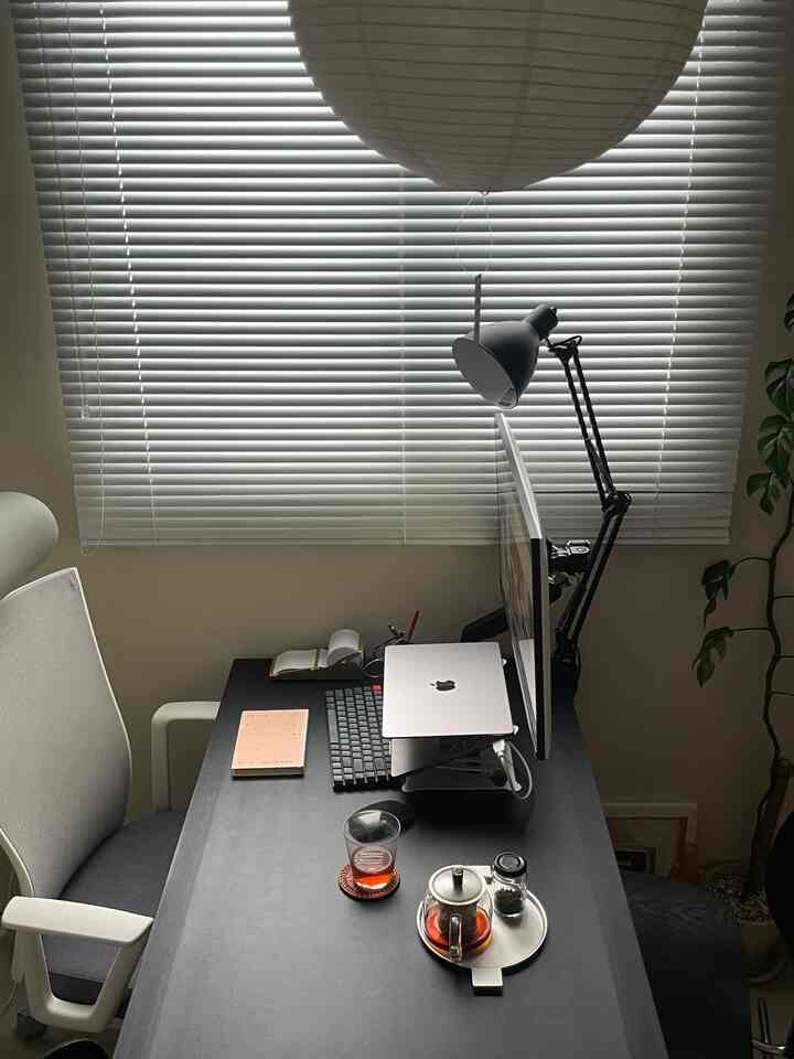 白いブラインドと黒いデスクが調和したモダンなホームオフィス、落ち着いた雰囲気のあるインテリア