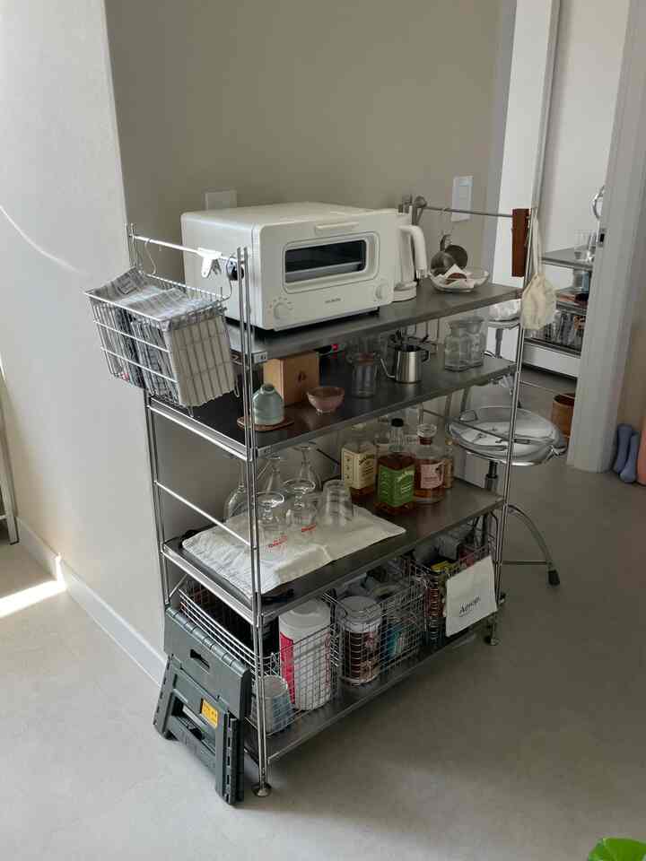 シルバー調のキッチンスペース、ステンレス棚にコーヒー器具やキッチン用品が整頓された雰囲気のあるインテリア