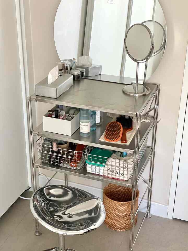 シルバーのステンレス棚と鏡が配置された、すっきりとした化粧台の空間